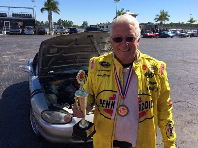 A man in yellow jacket holding a trophy.