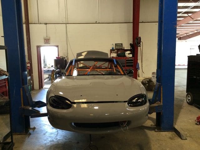 A car is being worked on in the shop.