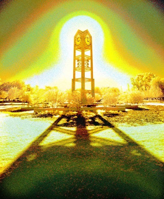 A large clock tower in the middle of a lake.