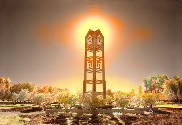 A clock tower with the sun shining through it.