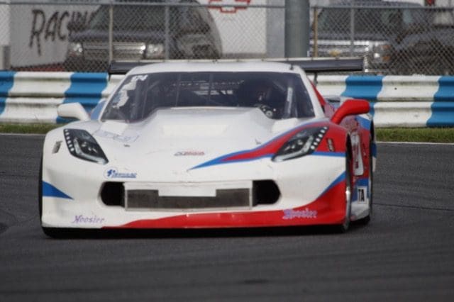 A white race car with red, blue and white stripes.