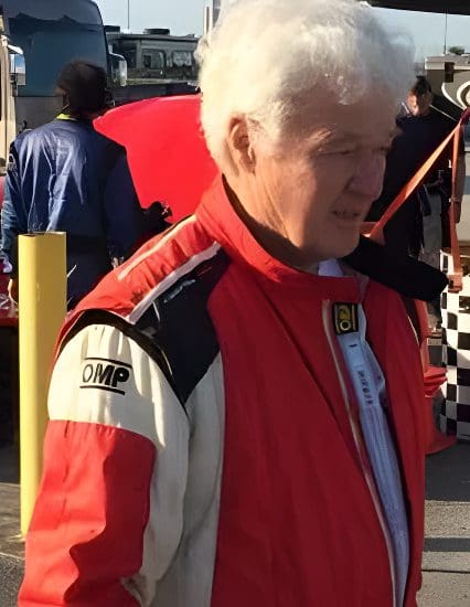 A man in red and white jacket holding an umbrella.