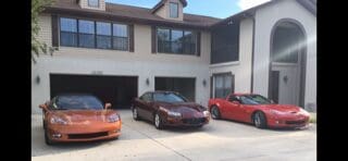 Three sports cars parked in front of a house.