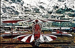A red and white biplane parked on the tarmac canvas print.